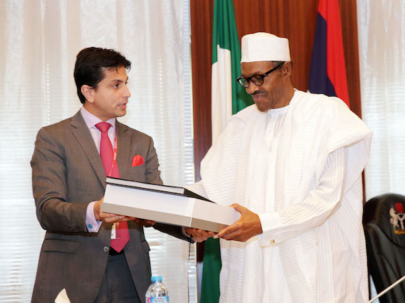 Mr Jaimal Shergill, a member of the Centenary City project presents some documents to President Buhari