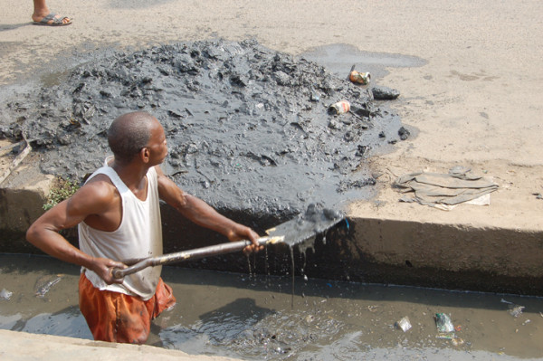 A worker clears the drains in Lagos