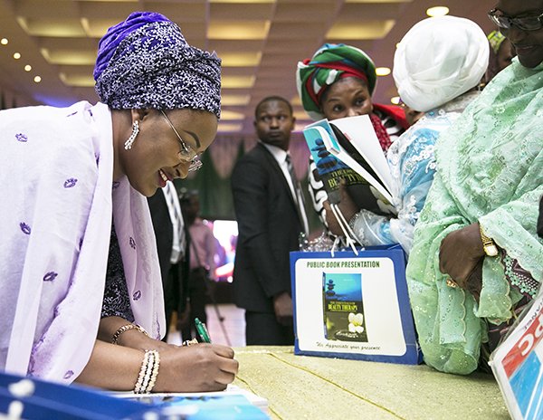 Aisha Buhari autographs the book
