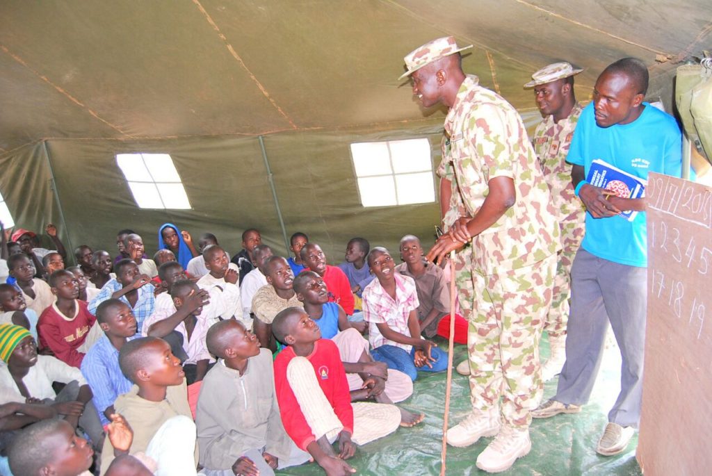 A Soldier attending to pupils in the 'classroom'