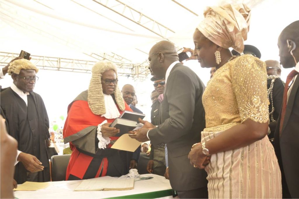 Chief Judge of Edo State, Hon. Justice Cromwell Idahosa, administering oath of office and allegiance on the new Governor. The new Governor's wife is by his side