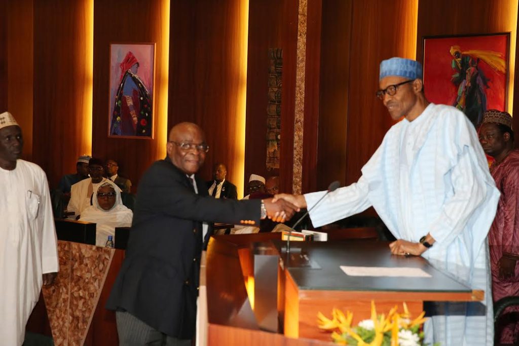President Buhari shakes Justice Walter Onnoghen after swearing him in as the Acting Chief Justice of Nigeria (CJN).