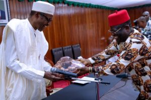 File: Governor Umahi (right) presents kolanut to welcome President Buhari to Ebonyi State