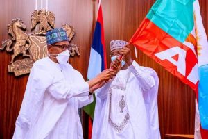 Governor Matawalle receiving APC flag from President Buhari when he defected to the party