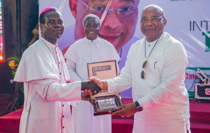 Governor Hope Uzodimma of Imo State (right), receives gift from the Auxiliary Bishop of Catholic Archdiocese of Owerri, Most Rev (Dr.) Moses Chikwe ( left) on behalf of the 2023 Pilgrims from Imo State while Government House Chaplain, Rev (Dr) Gilbert Alaribe watches at a thanksgiving service held by the Pilgrims to thank the Governor for sponsoring them at the Eze Imo Palace, Owerri... Sunday