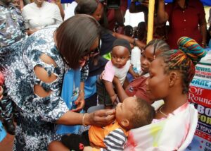 Rivers State Deputy Governor, Prof. (Mrs.) Ngozi Nma Odu (Left), performing the Symbolic Administration of Vitamin A on Children during the Flag-Off of Second Round-Maternal New Born and Child Health Week 2023 at the Opobo Town Hall on the 8th Dec. 2023.