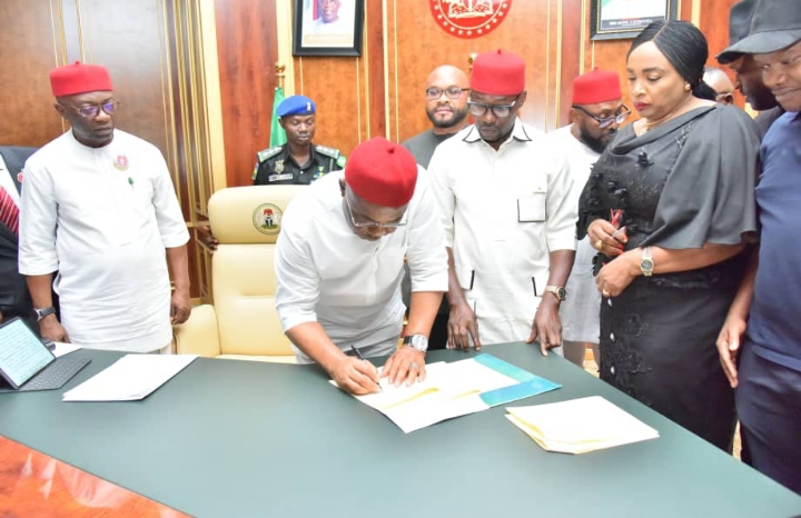 Governor Hope Uzodimma (middle) signs the Imo 2024 Budget into law, watched from left, the Deputy Governor, Prof. Placid Njoku, the Speaker, Rt. Hon Chike Olemgbe (second right) and the Clerk of the Assembly, Barr Chinelo Emeghara