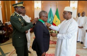 Aliko Dangote being decorated by President Macky Sall