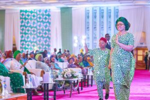 Wife of the Imo State Governor and Secretary of the Renewed Hope Initiative, RHI Mrs Chioma Uzodinma and her son on the runway, showcasing the newly unveiled #One Nigeria/Unity Fabric while the First Lady of Nigeria, Senator Oluremi Tinubu and others watch during the presentation of the prize money and unveiling of the #One Nigeria/Unity fabric at the banquet hall, State House, Abuja on Monday 16th September,2024
