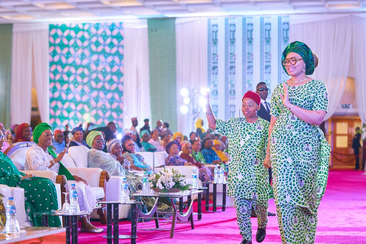 Wife of the Imo State Governor and Secretary of the Renewed Hope Initiative, RHI Mrs Chioma Uzodinma and her son on the runway, showcasing the newly unveiled #One Nigeria/Unity Fabric while the First Lady of Nigeria, Senator Oluremi Tinubu and others watch during the presentation of the prize money and unveiling of the #One Nigeria/Unity fabric at the banquet hall, State House, Abuja on Monday 16th September,2024
