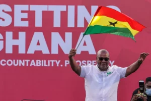John Mahama holds a Ghanaian flag as he waves to supporters during his final election campaign rally in Accra on December 5 [Zohra Bensemra/Reuters]