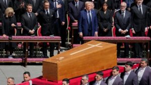 The coffin of Pope Francis is carried in front of dignitaries, including President Donald Trump, center, and French President Emmanuel Macron, during his funeral in St. Peter's Square at the Vatican, Saturday, April 26, 2025. (AP Photo/Gregorio Borgia)