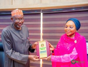 Governor Namadi receiving a plaque from Mrs. Garba during the visit