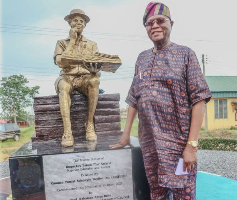 Prince Yemisi Shyllon standing beside the statue