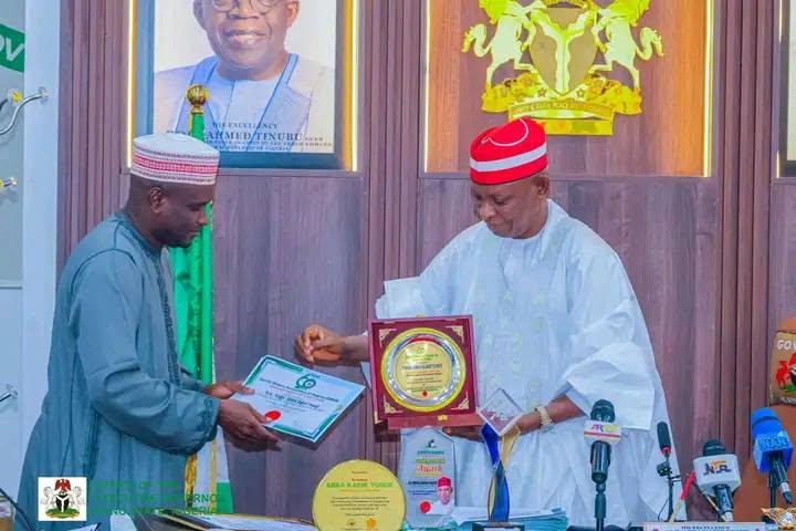 Sunusi Bature handing over some of the Awards to Governor Yusuf during the Council meeting